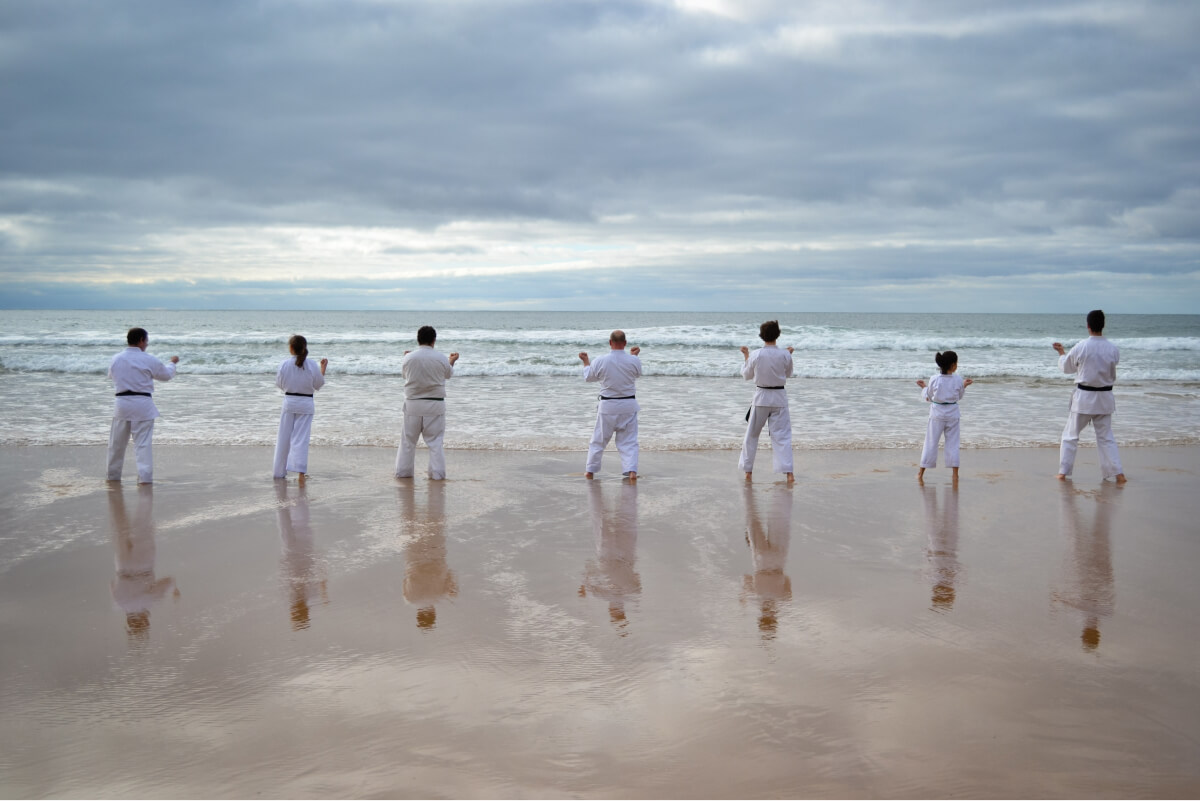 Group practicing tai chi on the beach